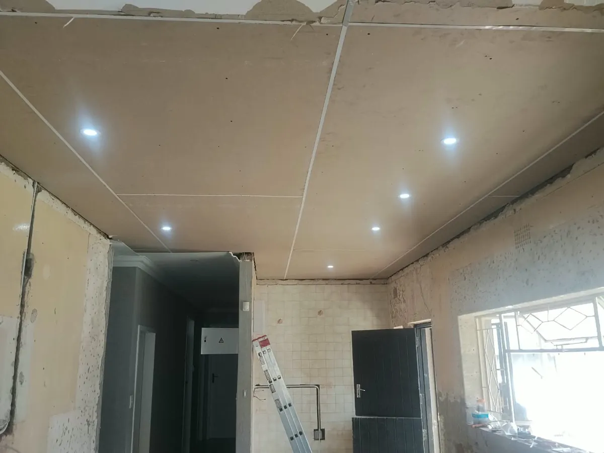 New ceiling boards with LED downlights fitted in a kitchen under renovation