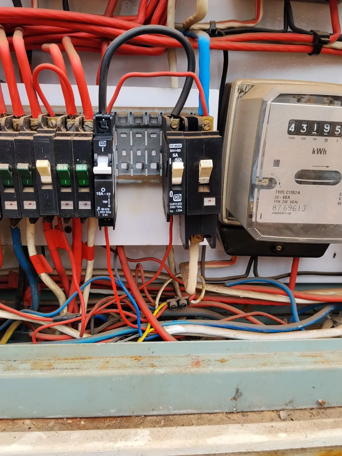 Close-up of circuit breakers and an electricity meter inside a distribution board