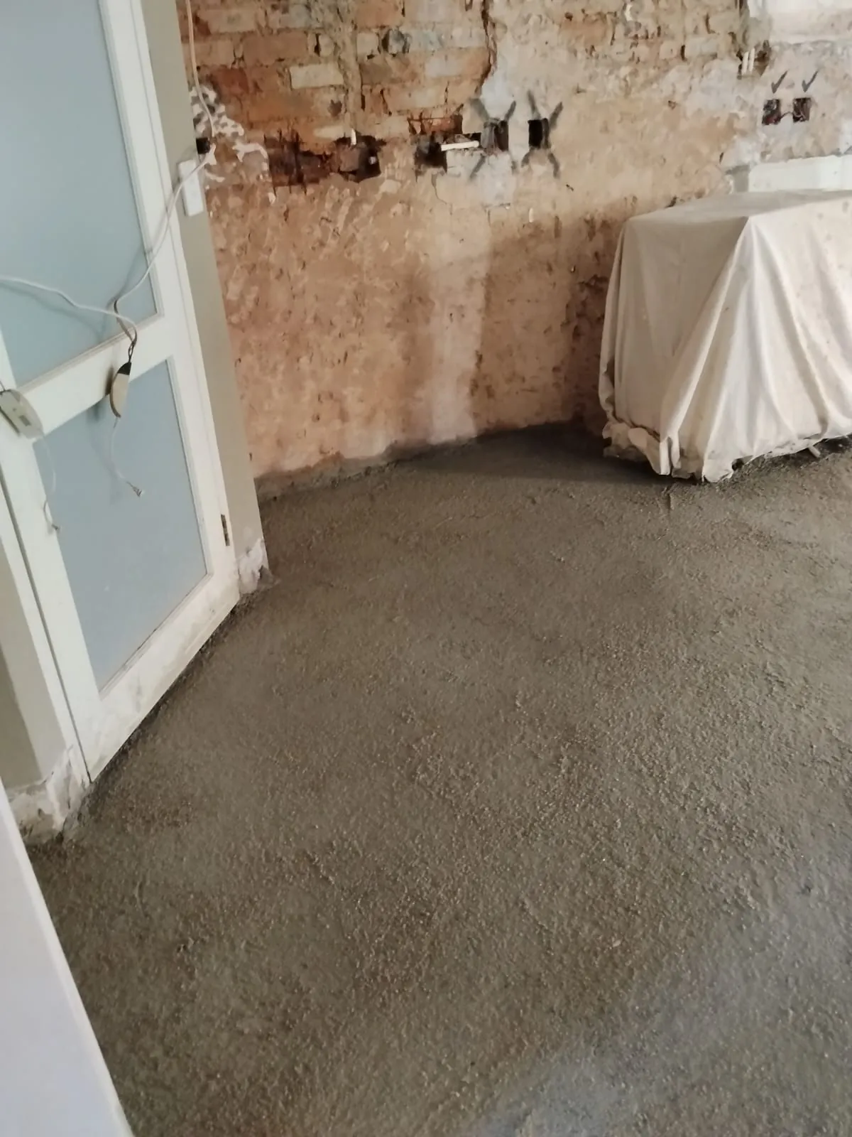 Fresh floor screed laid level in a room, ready for tiling
