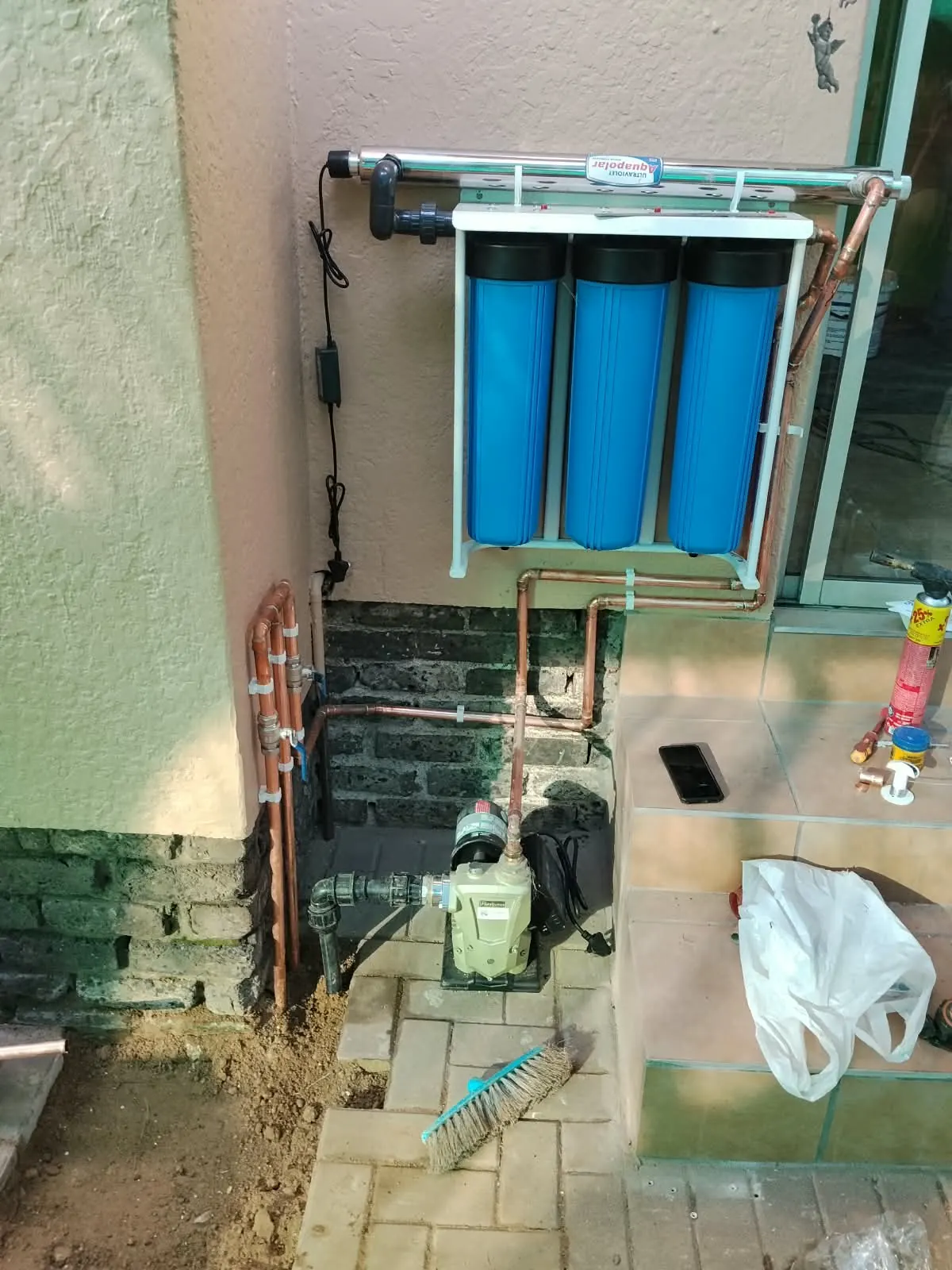 Three-stage water filter with UV unit and a booster pump connected in copper
